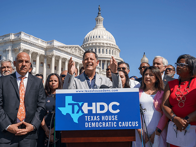 Rep. Rafael Anchia, chairman of the Mexican American Legislative Caucus, center, joined by Democratic members of the Texas legislature, speaks at a news conference at the Capitol in Washington, Tuesday, July 13, 2021, after they left Austin hoping to deprive the Legislature of a quorum to kill a Republican bill …