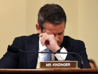 Rep. Adam Kinzinger (R-IL) wipes his eyes as he listens to testimony during the Select Com
