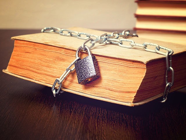 old book wrapped with chain and locked on padlock on table, concept, toned