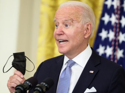 WASHINGTON, DC - JULY 29: U.S. President Joe Biden holds up a face mask as he delivers rem