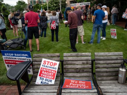 Signs are seen on a bench during a rally against "critical race theory" (CRT) being taught in schools at the Loudoun County Government center in Leesburg, Virginia on June 12, 2021. - "Are you ready to take back our schools?" Republican activist Patti Menders shouted at a rally opposing anti-racism …