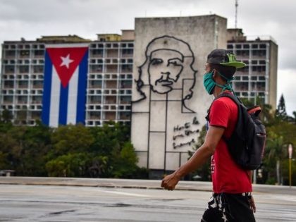 A man walks in front of the Interior Ministry building with the image of legendary guerrilla leader Ernesto "Che" Guevara at Havana's Revolution square, on May 1, 2020. - The Cuban government suspended the celebration of the largest annual march in the island, due to the Covid-19 pandemic, urging citizens …