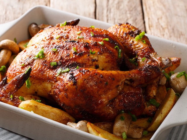 grilled chicken with mushrooms and potatoes close-up in a baking dish. horizontal - stock photo