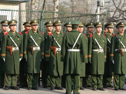 Chinese paramilitary officers stand at attention while on a routine drill in Beijing's foreign embassy district, 18 December 2007. The Chinese Paramilitary Forces are composed of thee main divisions, the People's Armed Police (PAP), the militia and the reserve force, all acting as auxiliaries to the People's Liberation Army (PLA). …