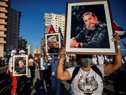 A woman holds a portrait of Cuban late leader Fidel Castro during an act of revolutionary reaffirmation in Havana, on July 17, 2021. - Former Cuban President Raul Castro and his successor, Miguel Diaz-Canel, led an "act of revolutionary reaffirmation" in front of thousands of supporters in Havana on July …
