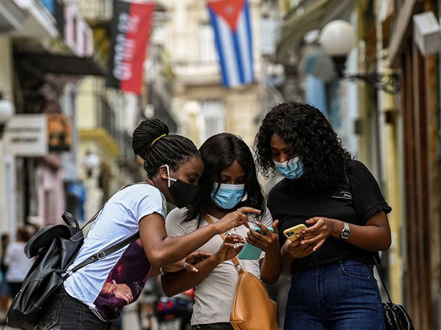 Women use their phones in a street of Havana, on July 14, 2021. - Cuban authorities restor
