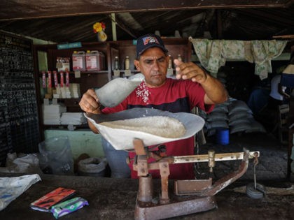 A man weighs rice at a store in San Luis, Santiago de Cuba province, on June 20, 2017. Each Cuban home receives certain basic foods every month for a pay of only a tenth of their market value thanks to a ration book launched in 1963, when the state started …