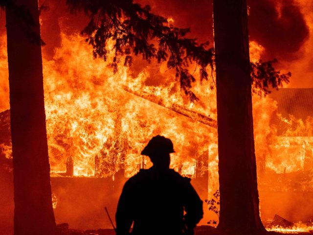 Firefighters attempt to get control of the scene as dozens of homes burn during the Dixie in the Indian Falls neighborhood of unincorporated Plumas County, California on July 24, 2021. - The Dixie fire, which started only a few miles from the origin of the deadly Camp fire, has churned …