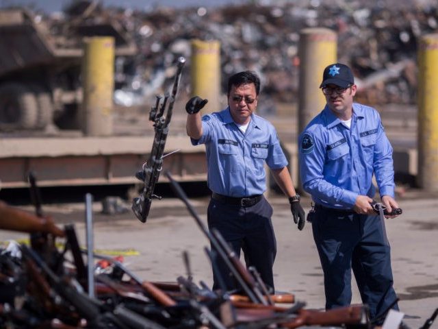 RANCHO CUCAMONGA, CA - JULY 19: Deputies toss guns onto a pile of approximately 3,500 confiscated weapons to be destroyed at Gerdau Steel Mill under supervision of the Los Angeles County Sheriffs Department and other law enforcement agencies on July 19, 2018 in Rancho Cucamonga, California. The weapons were seized …