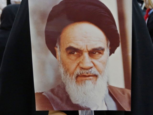 An Iranian girl holds a poster of Iran's late founder of the Islamic Republic, Ayatol