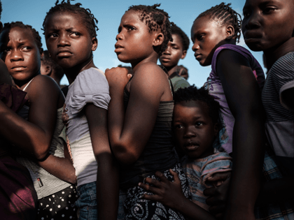 Children wait in line to receive food distribution from a local supermarket at an evacuation center in Dondo, about 35km north from Beira, Mozambique, on March 27, 2019. - Five cases of cholera have been confirmed in Mozambique following the cyclone that ravaged the country killing at least 468 people, …