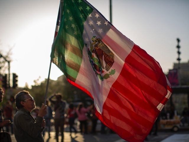 LOS ANGELES, CA - MAY 01: A man carries a U.S.flag and a flag of Mexico together as people march and rally on May Day, also known as International Workers Day, on May 1, 2019 in Los Angeles, California. People are participating in multiple May Day marches and rallies around …