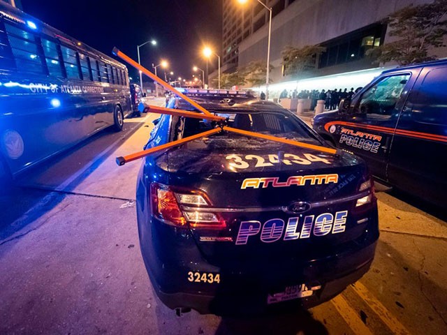 A police car is vandalized during rioting and protests in Atlanta on May 29, 2020. - The death of George Floyd on May 25 while under police custody has sparked violent demonstrations across the US. (Photo by John Amis / AFP) (Photo by JOHN AMIS/AFP via Getty Images)