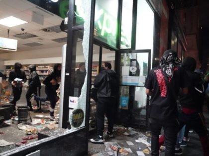 TOPSHOT - People loot a store during demonstrations over the death of George Floyd by a Mi