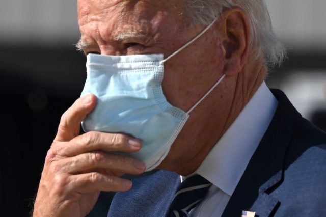 Democratic Presidential Candidate Joe Biden adjusts his double mask as he walks off the plane in Detroit, Michigan, on October 16, 2020. - Biden travels to Michigan for campaign stops. (Photo by JIM WATSON / AFP) (Photo by JIM WATSON/AFP via Getty Images)