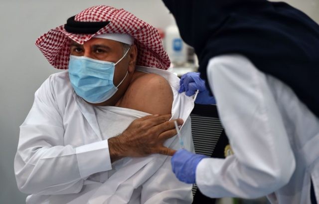 This picture taken on December 17, 2020 shows the first Saudi citizen preparing to receive the Pfizer-BioNTech COVID-19 coronavirus vaccine (Tozinameran) in the capital Riyadh, as part of a vaccination campaign by the Saudi health ministry. (Photo by FAYEZ NURELDINE / AFP) (Photo by FAYEZ NURELDINE/AFP via Getty Images)