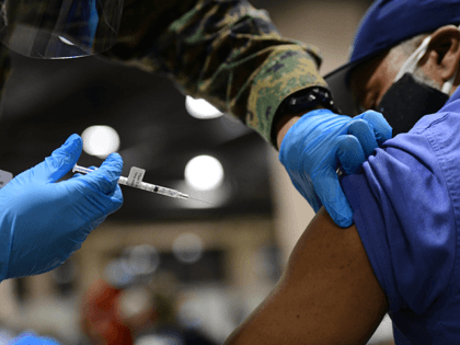 A member of the U.S. Armed Forces administers a dose of the Pfizer COVID-19 vaccine at a FEMA community vaccination center on March 2, 2021 in Philadelphia, Pennsylvania. Located at the Pennsylvania Convention Center, the site is being run as a partnership between the city and the federal government. It …