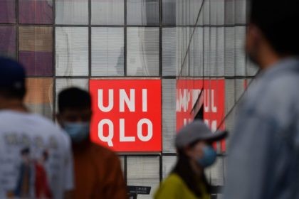 People walk past a Uniqlo clothing store in Beijing on March 25, 2021. (Photo by GREG BAKER / AFP) (Photo by GREG BAKER/AFP via Getty Images)