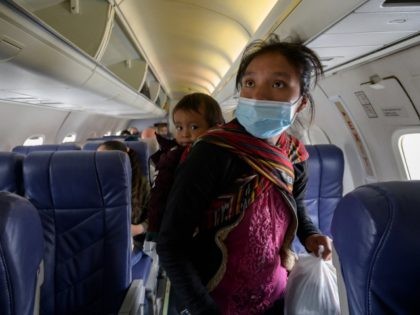 TOPSHOT - Central Americ migrant Filomena boards a flight from McAllen to Houston at McAllen airport after being released from a US government holding facility for illegal migrants seeking asylum in McAllen, Texas. - "Please help me, I don't speak English, "a manila envelope reads in large black letters with …
