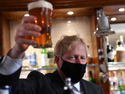 Britain's Prime Minister and leader of the Conservative Party, Boris Johnson, wearing a face covering due to Covid-19, poses after he poured a pint of beer at during a visit to The Mount Tavern pub and restaurant in Wolverhampton, central England, on April 19, 2021, while campaigning for the upcoming …