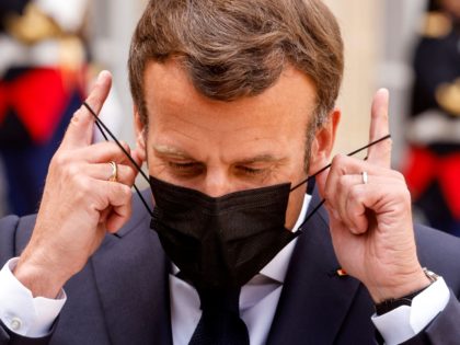 TOPSHOT - French President Emmanuel Macron removes his facemask before addressing the press in the courtyard of the Elysee presidential palace before a working lunch with Slovenia's Prime Minister in Paris on April 29, 2021. (Photo by Ludovic MARIN / AFP) (Photo by LUDOVIC MARIN/AFP via Getty Images)