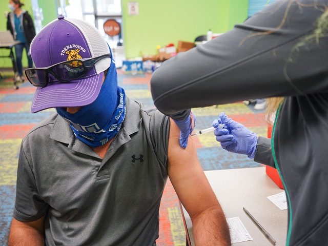 A healthcare vaccinates a man with the Covid-19 vaccine on April 30, 2021,as the Pasadena Public Library hosts a mobile vaccine clinic set up by the Harris County Public Health, in Pasadena, Texas. (Photo by Cécile CLOCHERET / AFP) (Photo by CECILE CLOCHERET/AFP via Getty Images)