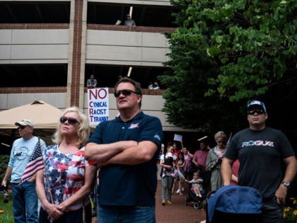 People listen to speakers during a rally against "critical race theory" (CRT) being taught in schools at the Loudoun County Government center in Leesburg, Virginia on June 12, 2021. - "Are you ready to take back our schools?" Republican activist Patti Menders shouted at a rally opposing anti-racism teaching that …