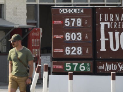 A pedestrian walks past gas station fuel prices above $5 and $6 per gallon at Death Valley National Park in June 17, 2021 in Furnace Creek, California. - Much of the western United States is braced for record heat waves this week, with approximately 50 million Americans placed on alert …