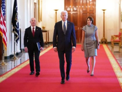 US President Joe Biden (C) flanked by Homeland Security Alejandro Mayorkas (L) and Acting Director of the United States Citizenship and Immigration Services (USCIS) Tracy Renaud, arrive at a naturalization ceremony for new citizens ahead of Independence Day in the East Room of the White House in Washington, DC on …
