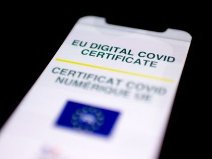 A picture taken on July 4, 2021 in Paris shows a mobile phone whose screen bears a EU Digital Covid certificate. - The European health certificate, which Belgium began using on June 16, 2021, has become operational across the EU on July 1, 2021. (Photo by Olivier MORIN / AFP) …