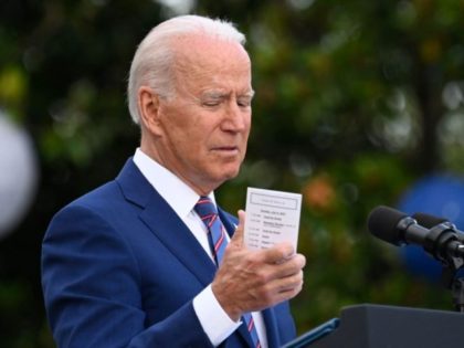 US President Joe Biden looks at the number of US deaths due to Covid-19 written on the back of his schedule as he speaks during Independence Day celebrations on the South Lawn of the White House in Washington, DC, July 4, 2021. (Photo by ANDREW CABALLERO-REYNOLDS / AFP) (Photo by …