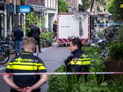 Police oficers work on the site of an attack during which a Dutch journalist specialised in crime, Peter R. de Vries was seriously injured in a shooting in Amsterdam, on July 6, 2021. - A well-known Dutch crime reporter was rushed to hospital with gunshot wounds on Tuesday after being …
