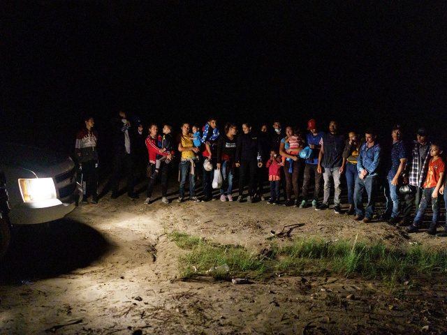 Migrant families are lined up after crossing the US-Mexico border into the United States in Roma, Texas on July 9, 2021 - Republican lawmakers have slammed Biden for reversing Trump programs, including his "remain in Mexico" policy, which had forced thousands of asylum seekers from Central America to stay south …
