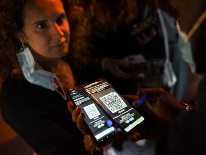A security staff member checks the health pass of a client, at the entrance of a nightclub in Saint-Jean-de-Monts, western France, on early July 10, 2021. - Nightlife fans across France can once again crowd into clubs starting July 9, 2021, though officials warned they would remain vigilant against any …