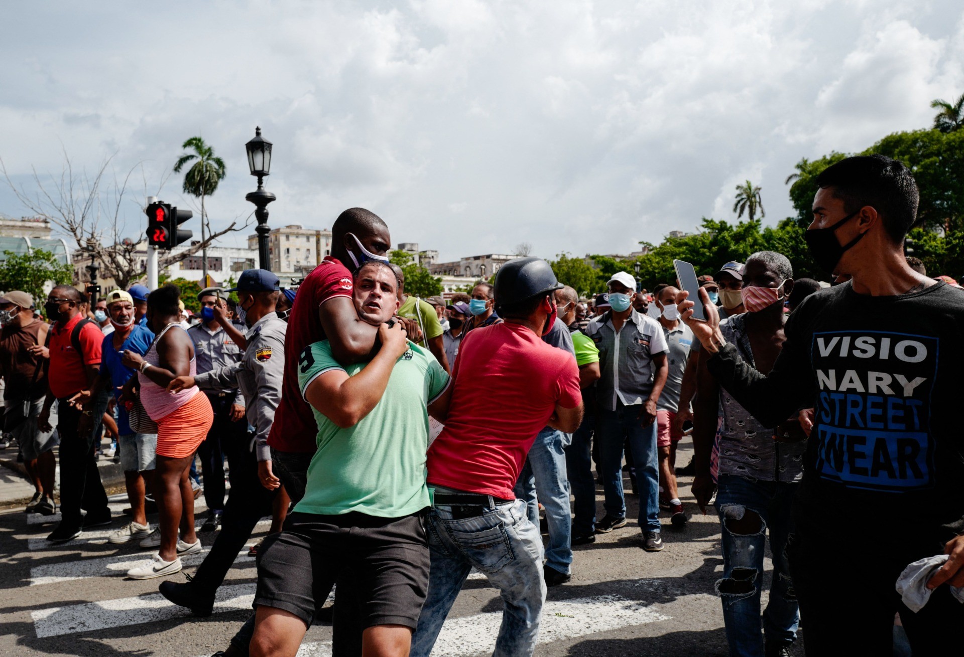 A man is seized by his neck during a demonstration against the government of Cuban President Miguel Diaz-Canel in Havana, on July 11, 2021. - Thousands of Cubans took part in rare protests Sunday against the communist government, marching through a town chanting "Down with the dictatorship" and "We want liberty." (Photo by ADALBERTO ROQUE / AFP) (Photo by ADALBERTO ROQUE/AFP via Getty Images)
