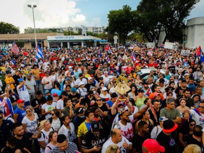 People demonstrate, some holding Cuban and US National flags, during a protest against the Cuban government in Miami on July 11, 2021. - Thousands of Cubans across the country took part in rare protests July 11, 2021, against the communist government, marching through several towns chanting, "Down with the dictatorship" …