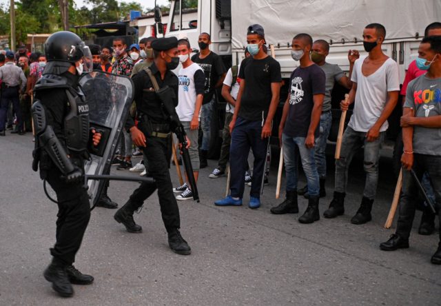 Riot police walk the streets after a demonstration against the government of President Miguel Diaz-Canel in Arroyo Naranjo Municipality, Havana on July 12, 2021. - Cuba on Monday blamed a "policy of economic suffocation" of United States for unprecedented anti-government protests, as President Joe Biden backed calls to end "decades …