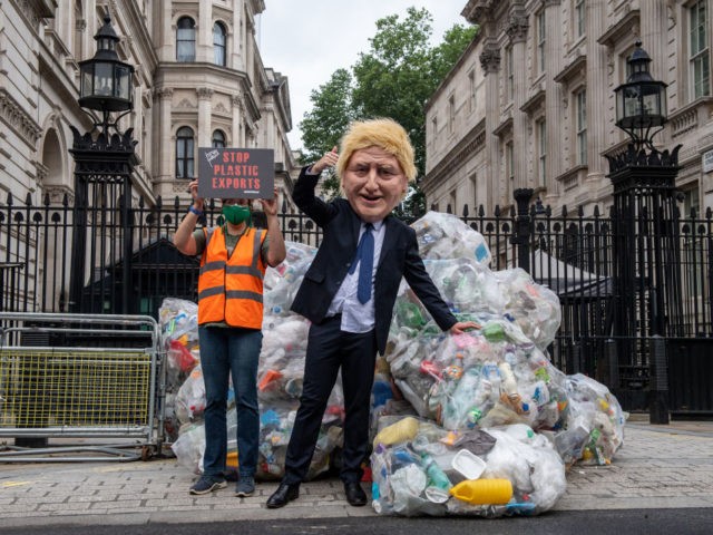 LONDON, ENGLAND - JULY 13: In this handout photo provided by Greenpeace, Greenpeace activists dump bags of plastic waste at the main entrance to Downing Street in a protest against the UK governments exporting of plastic waste on July 13, 2021 in London, England. 625 kilograms of plastic recycling has …