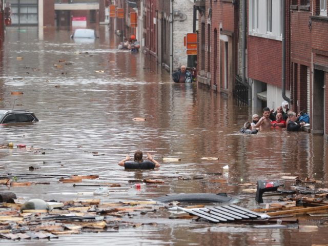 TOPSHOT - A woman is trying to move in a flooded street following heavy rains in Liege, on July 15, 2021. Illustration shows the scene in Liege after heavy rainfall, Thursday 15 July 2021. - The provincial disaster plan has been declared in Liege, Luxembourg and Namur provinces after large …
