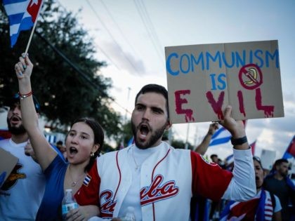 A man holds a sign reading "Communism is evil" during a protest showing support