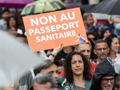 A woman holds a placard reading " NO to the health pass" during a demonstration against the compulsory vaccination for certain workers and the mandatory use of the health pass called by the French government, in Nantes, western France on July 24, 2021. - Since July 21, people wanting to …