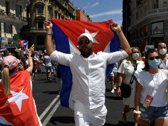 Protesters waving Cuban flags march along the Gran Via avenue in Madrid on July 25, 2021 in support of anti-government protests that were held in Cuba. (Photo by PIERRE-PHILIPPE MARCOU / AFP) (Photo by PIERRE-PHILIPPE MARCOU/AFP via Getty Images)