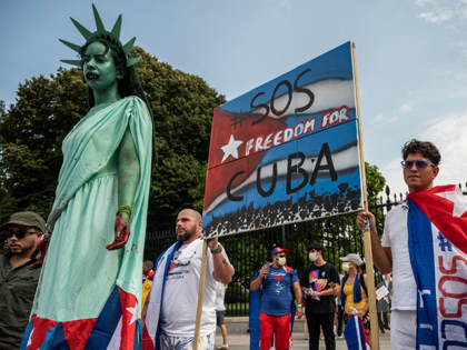 A protester dresses as the Statue of Liberty as others wear Cuban flags during a demonstration in front of the White House in Washington DC, on July 25, 2021. - Rallies are taking place around the world as Cuba endures its worst economic crisis in 30 years, with chronic shortages …