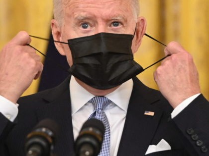 US President Joe Biden takes off his face mask before speaking about Covid vaccinations in the East Room of the White House in Washington, DC, July 29, 2021. (Photo by SAUL LOEB / AFP) (Photo by SAUL LOEB/AFP via Getty Images)