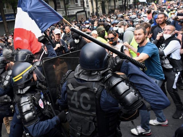 CRS riot police charge demonstrators on the sidelines of a demonstration as part of a national day of protest against French legislation making a Covid-19 health pass compulsory to visit a cafe, board a plane or travel on an inter-city train, in Paris on July 31, 2021. - The legislation …