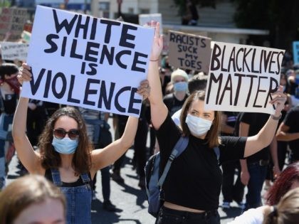 BRIGHTON, UNITED KINGDOM - JUNE 13: Thousands of protestors hold signs as they attend a Black Live Matters rally on June 13, 2020 in Brighton, United Kingdom. Black Lives Matter Rallies continue across the UK following the death on 25 May 2020 of an African American man, George Floyd, while …