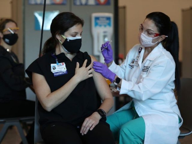 MIRAMAR, FLORIDA - DECEMBER 14: Diana Carolina, a pharmacist at Memorial Healthcare System, receives a Pfizer-BioNtech Covid-19 vaccine from Monica Puga, ARNP at Memorial Healthcare System, on December 14, 2020 in Miramar, Florida. The hospital system announced it will be vaccinating their frontline workers that are in contact with COVID-19 …