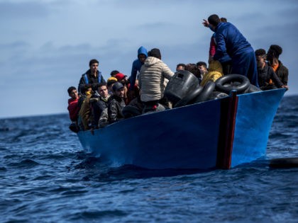 AT SEA - MARCH 29: Migrants of different nationalities aboard a wooden boat before being r
