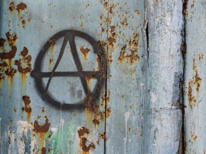 black sign of anarchy on an old fence. culture of anarchists, punks and street protests. S