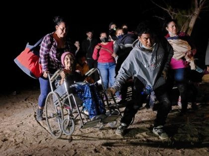 ROMA, TEXAS - APRIL 29: Honduran immigrant Trinidad Tabora, 93, is wheeled from the bank of the Rio Grande after crossing the border from Mexico on April 29, 2021 in Roma, Texas. She and her granddaughter (L) were smuggled across the border with other Central American asylum seekers during the …
